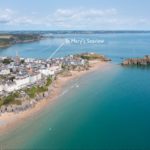 Aerial view of the coastal town of Tenby, featuring a sandy beach, colourful buildings, and St Catherine's Island, with a line pointing to St Mary's Seaview, a Christian holiday flat.