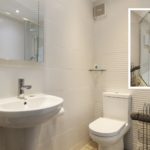 Bathroom in a Tenby holiday flat featuring a white pedestal basin, toilet, and an inset view of a shower enclosure with a glass door.